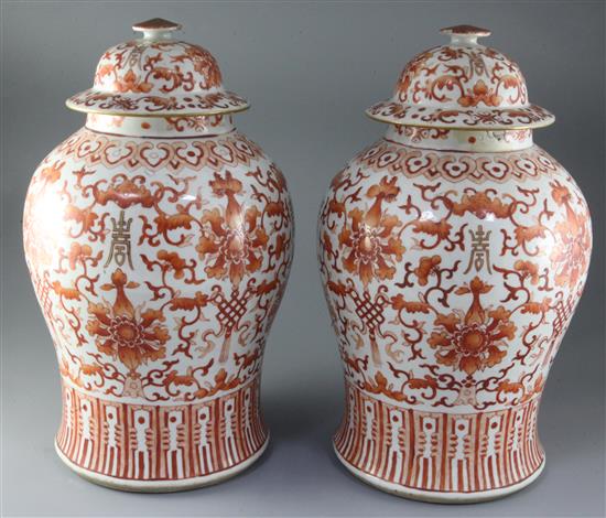 A pair of large Chinese iron red and gilt decorated baluster jars and cover, 19th century, height 43cm, chips to finials on covers